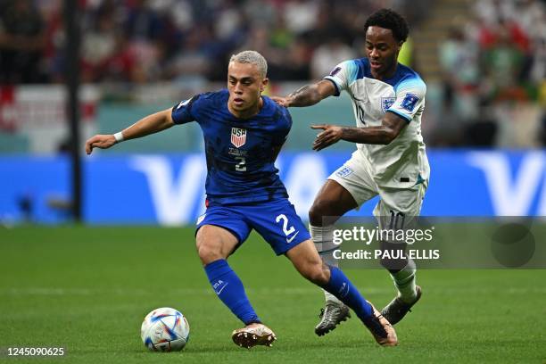 S defender Sergino Dest and England's forward Raheem Sterling fight for the ball during the Qatar 2022 World Cup Group B football match between...