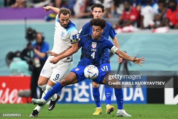 England's forward Harry Kane and USA's midfielder Tyler Adams fight for the ball during the Qatar 2022 World Cup Group B football match between...