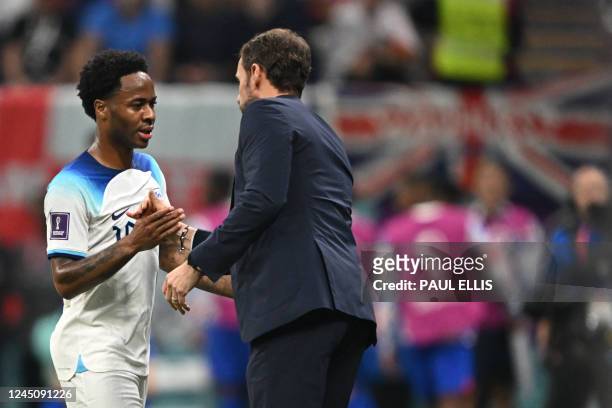 England's forward Raheem Sterling shakes hands with England's coach Gareth Southgate as he leaves the pitch during the Qatar 2022 World Cup Group B...