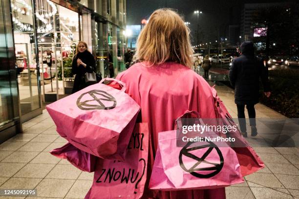 Extinction Rebellion protesting against Black Friday &amp; Fast Fashion in Warsaw, Poland. Climate activists gathered in front of one of Warsaw city...