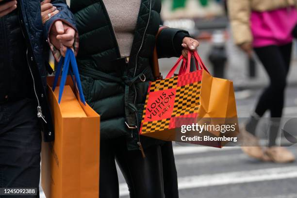 Pedestrian carries a Louis Vuitton shopping bag on Black Friday in New York, US, on Friday, Nov. 25, 2022. US retailers are bracing for a...