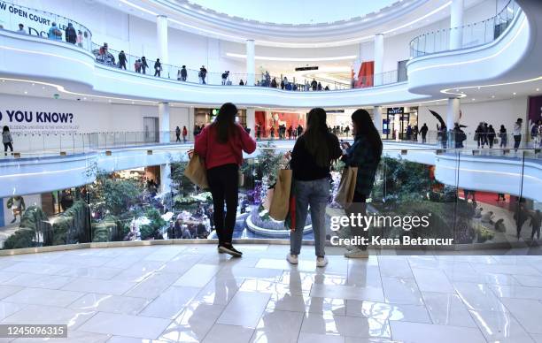 Women carry shopping bags as customers visit the American Mall dream mall during Black Friday on November 25, 2022 in East Rutherford, New Jersey....