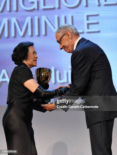 Actress Deanie Yip of "A Simple Life" accepts the Coppa Volpi for Best Actress from jury member Andre Techine during the Closing Ceremony during the...