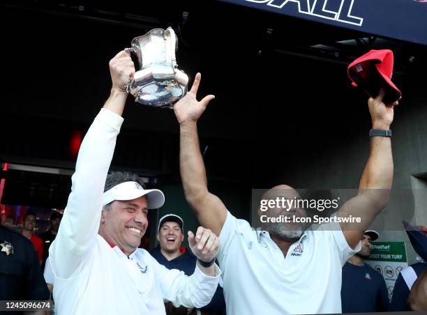 Arizona Wildcats head coach Jedd Fisch holds up the Territorial Cup and with assistant coach Ricky Hunley celebrates beating the Arizona State Sun...
