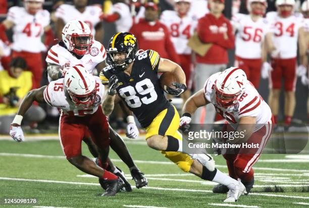 Wide receiver Nico Ragaini of the Iowa Hawkeyes runs up the field during the second half between linebacker Ernest Hausmann and defensive lineman...