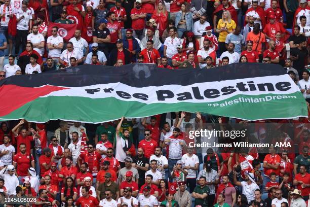 Fans hold a Flag of Palestine with Free Palestine written on it during the FIFA World Cup Qatar 2022 Group D match between Tunisia and Australia at...