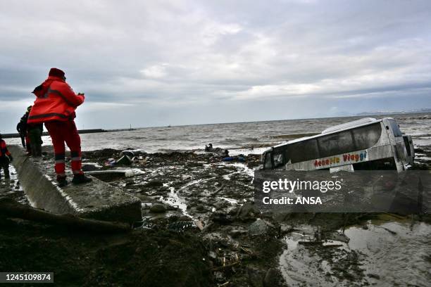 Rescue members look at damaged cars in the southern Ischia island on November 26 following heavy rains that sparked a landslide. - Italy's interior...