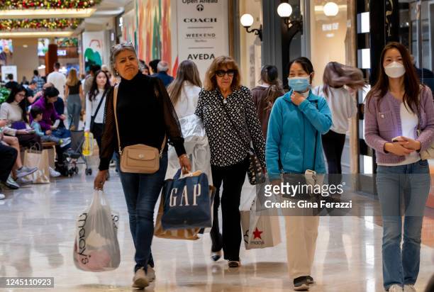 Shoppers carry their purchases while shopping on Black Friday at South Coast Plaza on November 25, 2022 in Costa Mesa, California.