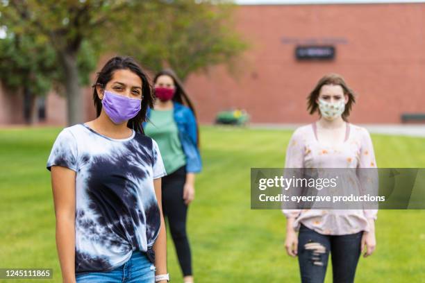 group of generation z multi-ethnic female friends wearing face masks and social distancing - generation z covid stock pictures, royalty-free photos & images