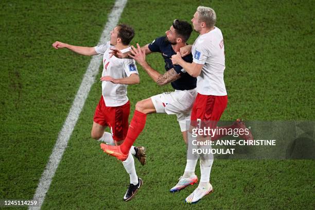 France's forward Olivier Giroud fights for the ball with Denmark's defender Simon Kjaer and Denmark's defender Victor Nelsson during the Qatar 2022...