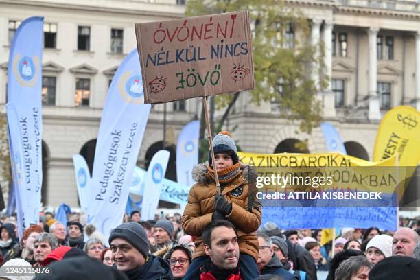 Young participant holds up a placard reading 'There is no future without the kindergarten teacher!' as teachers, students, parents, union activists...