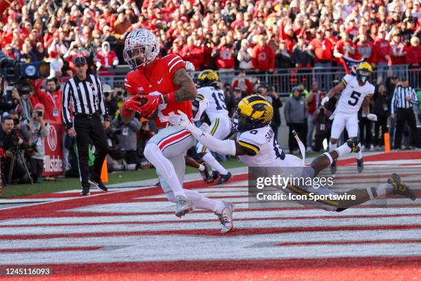 Ohio State Buckeyes wide receiver Emeka Egbuka catches a touchdown pass as Michigan Wolverines defensive back Mike Sainristil defends during the...