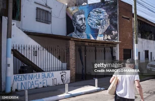 Man walks past a mural depicting Argentine football star Lionel Messi in his childhood neighborhood in Rosario, Argentina, on November 26, 2022.