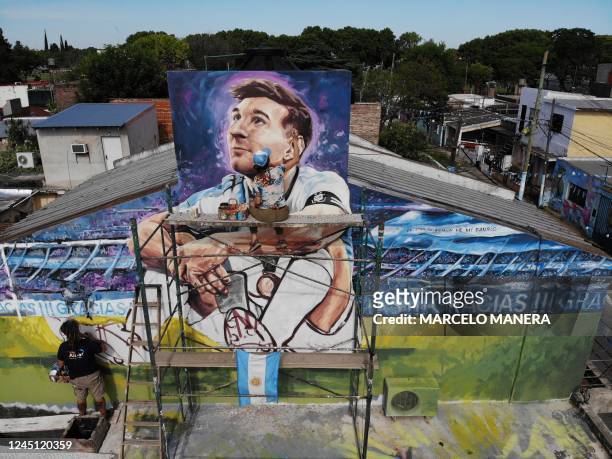 Artists Marlene Zuriaga and Lisandro Urteaga finish the details of a mural depicting Argentine football star Lionel Messi in his childhood home in...