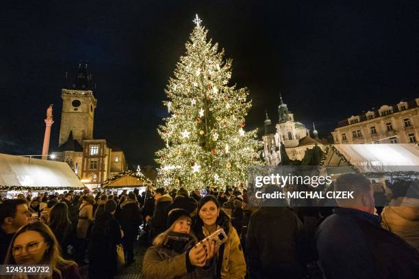 People take a selfie with the Christmas tree at the Christmas market at Old Town Square of the Czech capital in Prague.