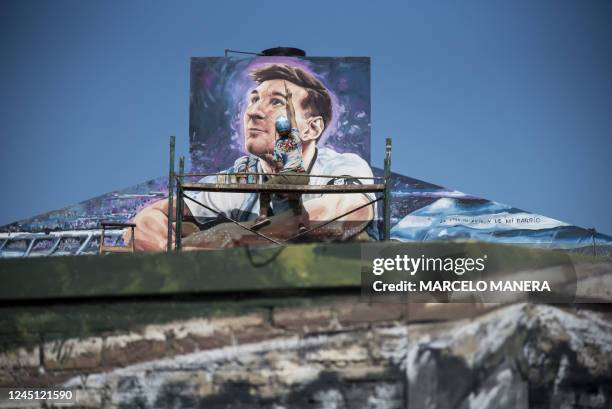 Artist Marlene Zuriaga finishes the details of a mural depicting Argentine football star Lionel Messi in his childhood home in Rosario, Argentina, on...