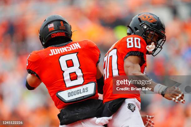 Wide receiver Brennan Presley of the Oklahoma State Cowboys celebrates his four-yard touchdown with wide receiver Braydon Johnson against the West...