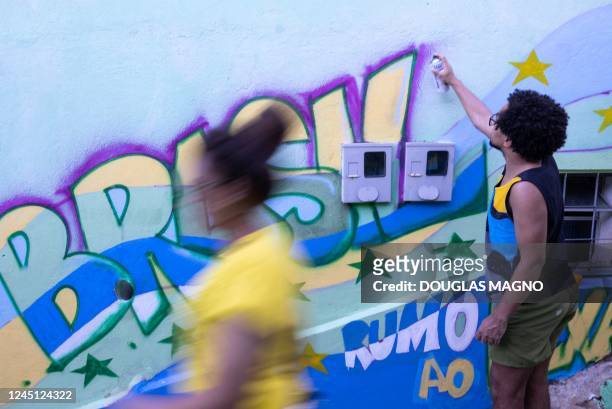 Man paints a wall during an artistic intervention in Belo Horizonte, state of Minas Gerais, Brazil, on November 26, 2022. - The social project Eu Amo...