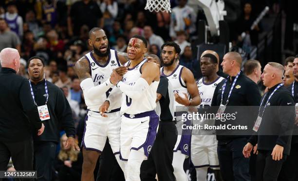 LeBron James of the Los Angeles Lakers checks on Russell Westbrook of the Los Angeles Lakers after he received a hit on a drive to the basket by Zach...