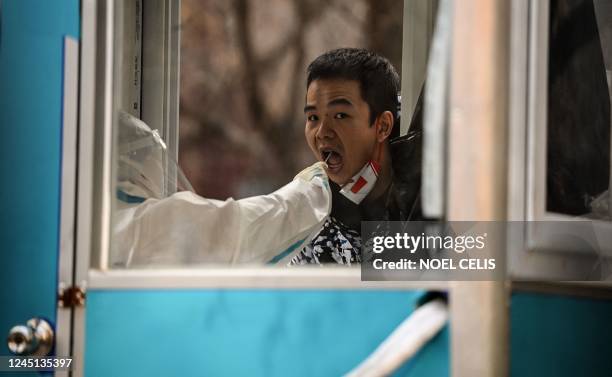 Health worker takes a sawb sample from a man to be tested for Covid-19 coronavirus at a residential area under lockdown due to Covid-19 coronavirus...