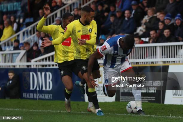 Hartlepool United's Josh Umerah in action with Harrogate Town's Warren Burrell and Kayne Ramsay during the FA Cup Second Round match between...