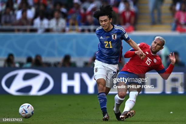 Japan's forward Ayase Ueda fights for the ball with Costa Rica's defender Francisco Calvo during the Qatar 2022 World Cup Group E football match...