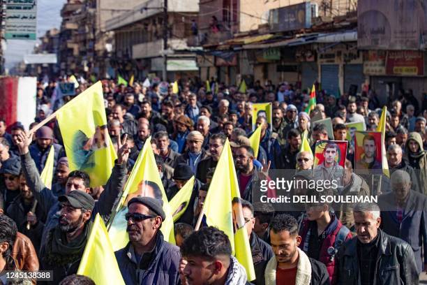 Syrian-Kurdisg demonstrators raise flags bearing an image of jailed leader Abdullah Ochalan, as they protest against Turkey's threats against their...