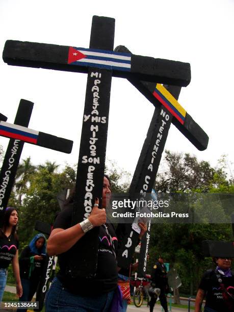 Women holding black crosses with flags of Cuba and Venezuela when thousands of women took to the street of Lima as part of the activities of the...