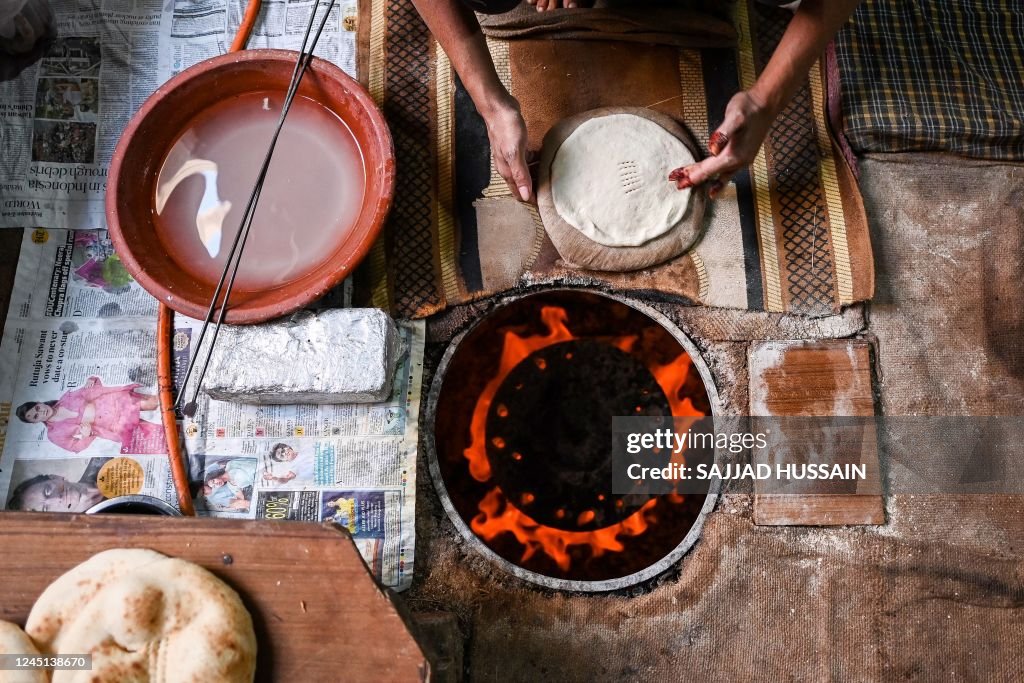 Indian Roti Stand A worker prepares roti - a form of bread popular in India at a bakery ...