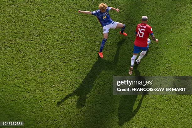 Japan's midfielder Junya Ito fights for the ball with Costa Rica's defender Francisco Calvo during the Qatar 2022 World Cup Group E football match...