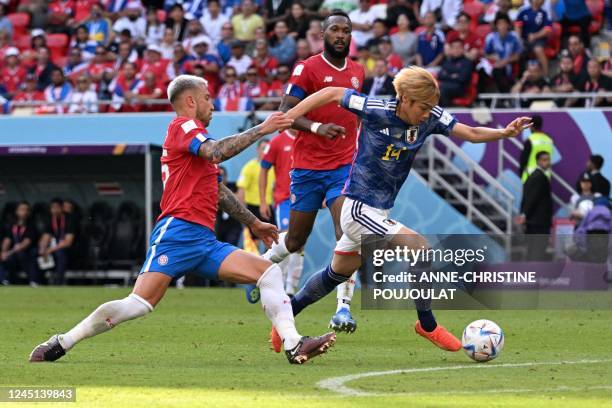 Costa Rica's defender Francisco Calvo fouls Japan's midfielder Junya Ito during the Qatar 2022 World Cup Group E football match between Japan and...