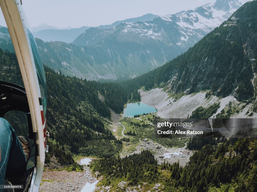 Looking out of helicopter while flying over a mountain lake near Squamish