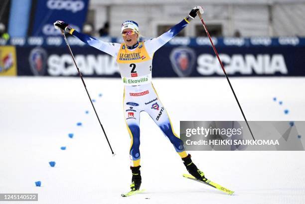 Sweden's Frida Karlsson celebrates after crossing the finish line to win the cross-country 20km pursuit freestyle competition of the Women's FIS Ski...