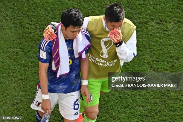 Japan's midfielder Wataru Endo and Japan's goalkeeper Eiji Kawashima recat after they lost the Qatar 2022 World Cup Group E football match between...