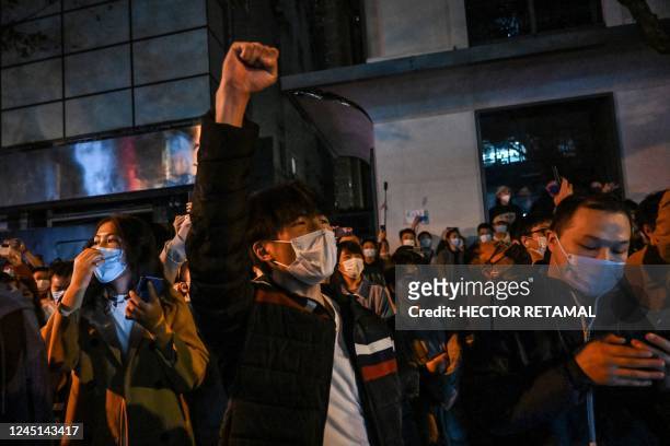 People sing slogans while gathering on a street in Shanghai on November 27 where protests against China's zero-Covid policy took place the night...