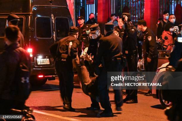 Man is arrested while people gathering on a street in Shanghai on November 27 where protests against China's zero-Covid policy took place the night...