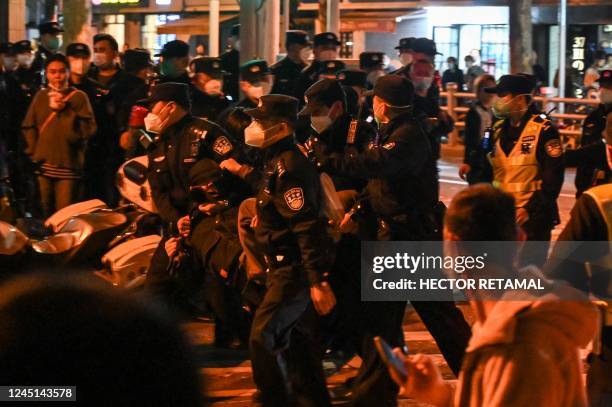 Man is arrested while people gathering on a street in Shanghai on November 27 where protests against China's zero-Covid policy took place the night...