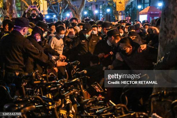 Police arrest a protester during some clashes in Shanghai on November 27 where protests against China's zero-Covid policy took place the night before...