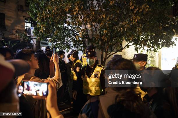 Police officers stand guard during a protest in Shanghai, China, on Sunday, Nov. 27, 2022. Protests against Covid restrictions spread across China on...