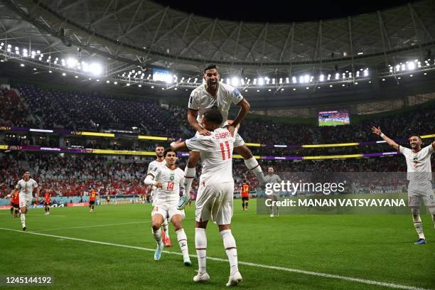 Morocco's midfielder Abdelhamid Sabiri celebrates with teammates after he scored his team's first goal during the Qatar 2022 World Cup Group F...