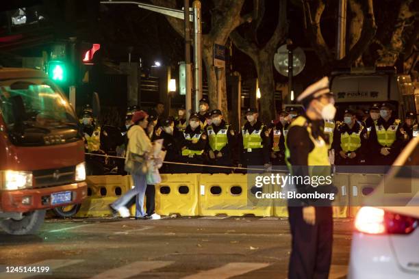 Police officers stand guard during a protest in Shanghai, China, on Sunday, Nov. 27, 2022. Protests against Covid restrictions spread across China on...