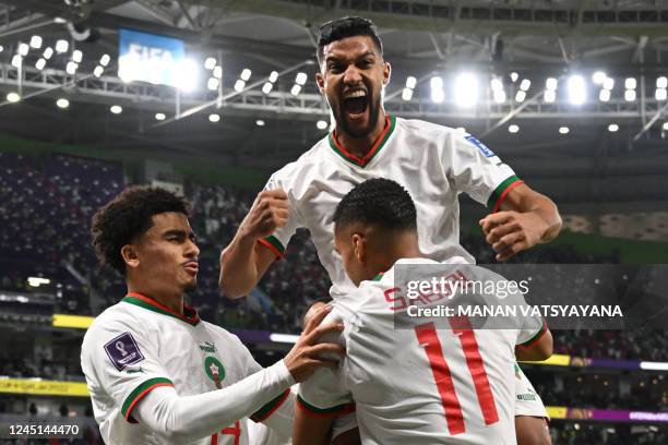 Morocco's midfielder Abdelhamid Sabiri celebrates with Morocco's forward Zakaria Aboukhlal and Morocco's defender Yehia Attiyallah after he scored...