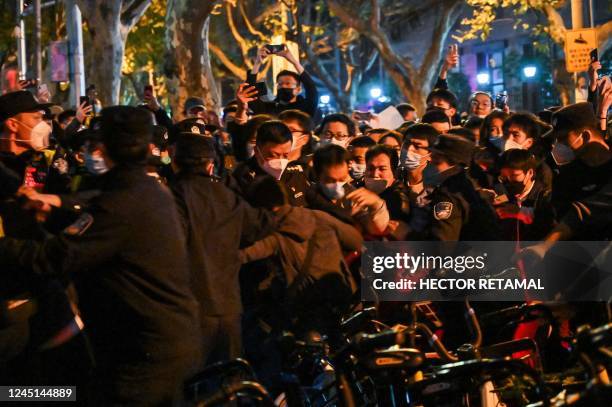 Police and people are pictured during some clashes in Shanghai on November 27 where protests against China's zero-Covid policy took place the night...