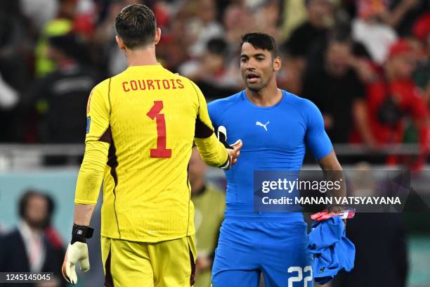 Morocco's goalkeeper Monir El Kajoui shakes hands with Belgium's goalkeeper Thibaut Courtois after Morocco won the Qatar 2022 World Cup Group F...