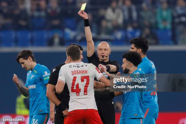 Referee Vladimir Moskalev shows yellow card to Roman Zobnin of Spartak Moscow during the Russian Cup match between FC Zenit Saint Petersburg and FC...