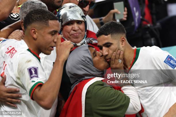 Morocco's defender Achraf Hakimi is greeted by his mother beside midfielder Abdelhamid Sabiri at the end of the Qatar 2022 World Cup Group F football...