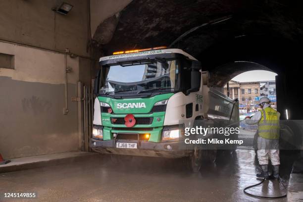 Workers jet wash the mud off site trucks at the massive redevelopment project construction site at Elephant and Castle on 17th November 2022 in...