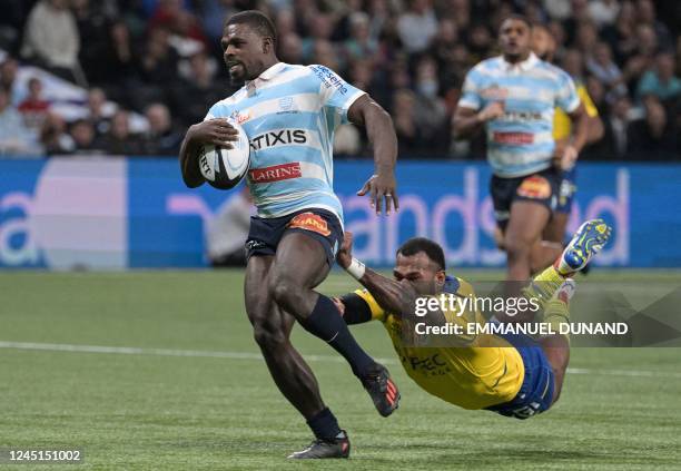 Racing92's English wing Christian Wade runs with the ball to score a try as he is avoiding Clermont's Fijian wing Alivereti Raka's tackle during the...