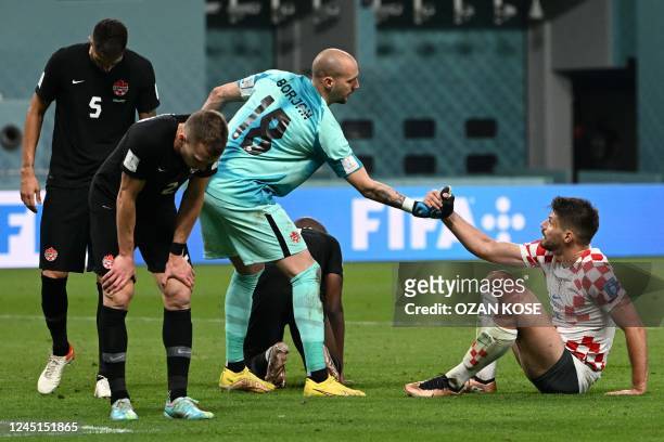 Canada's goalkeeper Milan Borjan helps Croatia's forward Bruno Petkovic to stand up after being defeated by Croatia 4-1 in the Qatar 2022 World Cup...