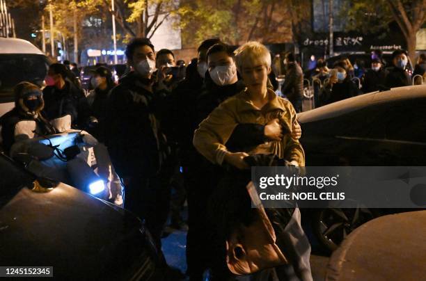 Protester scuffles with police during a rally for the victims of a deadly fire as well as a protest against China's harsh Covid-19 restrictions in...